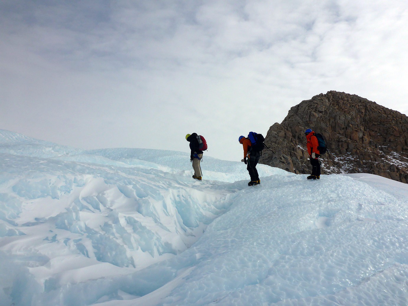 The sampling team ascends a peak to recover bedrock samples from the Ohio Range